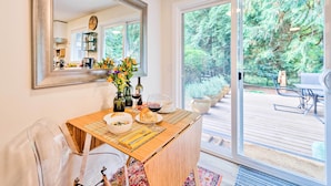 A dining area with a wooden table, chairs, and a large mirror. - House w/ Deck on Whidbey Island, 1 Mi from Shore! (Clinton)