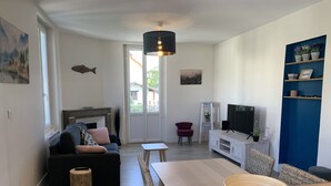 Una sala de estar moderna con un sofá, televisor y una mesa de comedor con un tazón.