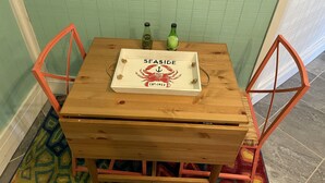 A small wooden table with a white box labeled "SEASIDE" and a green bottle on it. - Perfect Couples Getaway - Canal Front Apartment  (Eastpoint)