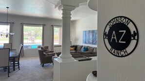 A spacious living room with a high ceiling, a dining area, and a view of a pool. - Luxurious Golf Course Views-Private Pool +2 King Suites-Sleeps 8 (San Tan Valley)
