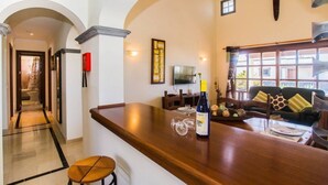 A modern interior with a bar area, a dining space, and a living area with a sofa and cushions. - Villa Eleonor in Playa Blanca (Playa Blanca)