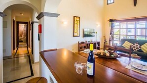 A modern living room with a wooden dining table, a TV, and a sofa. - Villa Eleonor in Playa Blanca (Playa Blanca)