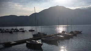 Un port de plaisance avec des bateaux amarrés, une eau calme et des montagnes en arrière-plan.