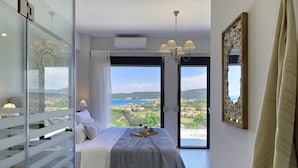 A bedroom with a large bed, a view of the sea, and a balcony. - Soleado Luxury Villas (Kassandra)