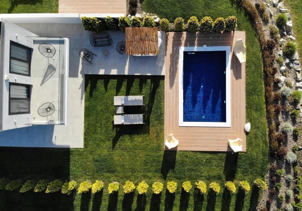 A modern outdoor living area with a pool, a barbecue, and a seating area.