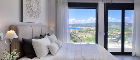 Ein Schlafzimmer mit einem großen Bett, Blick auf eine Stadt durch eine Schiebetür, einer Wand-Klimaanlage und einer Deckenleuchte.