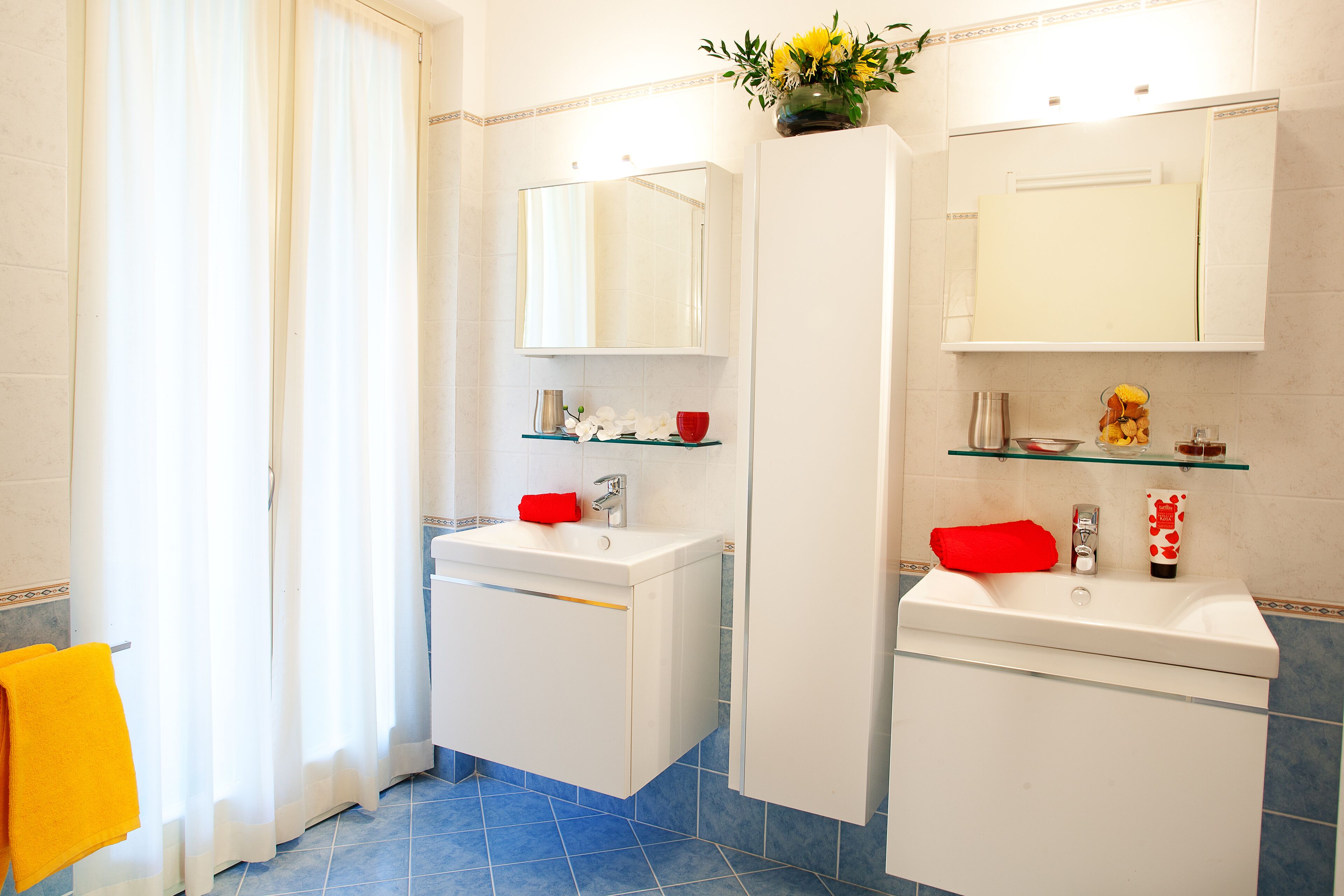 A bathroom with two sinks, a mirror above each, and a shower curtain.
