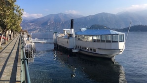 Un barco atracado en un muelle, con una vista despejada de montañas al fondo.