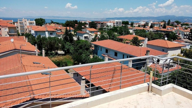 A residential area with terracotta-tiled roofs, a clear sky, and distant mountains. - Luxury Apartment Thermaikos (Thermaikos)