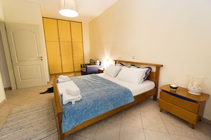 A bedroom with a bed, bedside tables, a wardrobe, and a door.