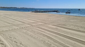 A sandy beach with a pier extending into the water, boats, and a clear blue sky. - Three double bedroom townhouse in lovely village (San Javier, Murcia)