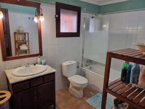 A bathroom with a sink, toilet, and shower. There is a wooden shelf with toiletries. - Three double bedroom townhouse in lovely village (San Javier, Murcia)