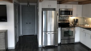A modern kitchen with stainless steel appliances, a microwave, and a coffee maker.