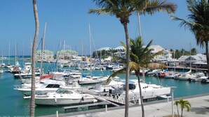 A marina with multiple boats docked, surrounded by palm trees and buildings in the background. - Ti Treasure Apartment Ground Floor T3 Crystal Beach (Saint-François)