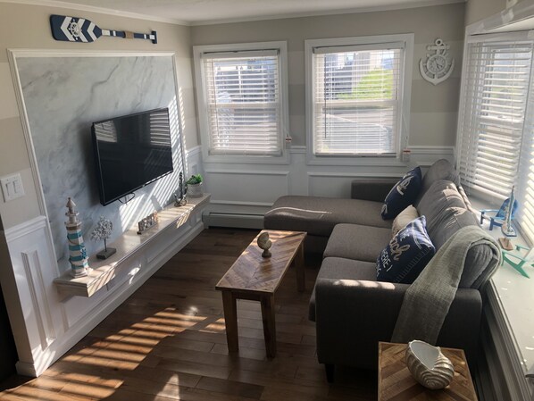 A living room with a flat-screen TV, a fireplace, a sofa, and a coffee table.