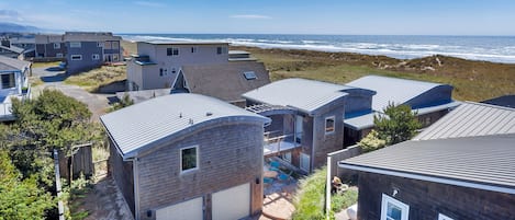 Ein Küstenwohngebiet mit modernen Häusern, Blick auf den Strand und blauem Himmel.