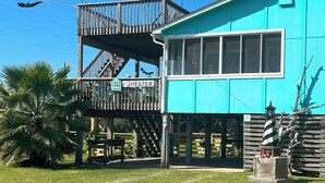 A turquoise building with a wooden deck and a sign that reads "Shelter." - In The Heart of Hatteras Village. Close to Beach, Restaurants and Marinas. (Hatteras)