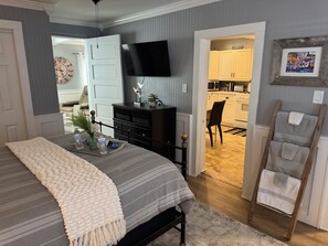 A bedroom with a bed, bedside table, and a TV mounted on the wall. - Close to Beach and Tarpon Springs Sponge Docks. Cottage on Spring Bayou (Tarpon Springs)