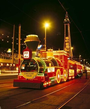 Un treno circolare ben illuminato, con la scritta 'FF' e 'GIRO CIRCOLARE', che viaggia sui binari di notte.