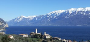 A coastal town with a prominent church and a mountain range in the background.