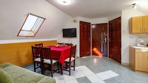 A compact living space with a dining area, a kitchenette, and a small seating area. - Captain 2 by Interhome (Siofok)