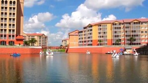Un hôtel situé au bord de l’eau, composé de plusieurs bâtiments, avec une rivière paisible et des bateaux en forme de cygne.