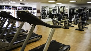 Une salle de sport équipée de tapis de course, de vélos d’appartement et d’appareils de musculation.