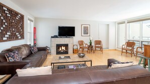 A modern living room with a fireplace, leather sofa, and wicker chairs. - Cozy Couple's Retreat in Downtown Telluride (Telluride)