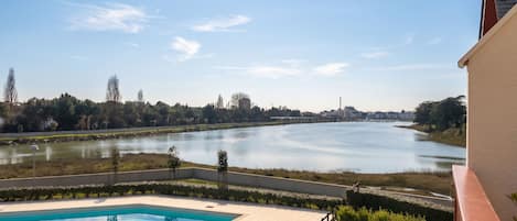 A swimming pool with a view of a river and distant buildings.