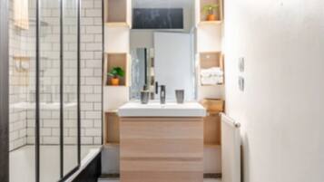 Een bad/douchecombinatie, een haardroger, handdoeken, toiletpapier