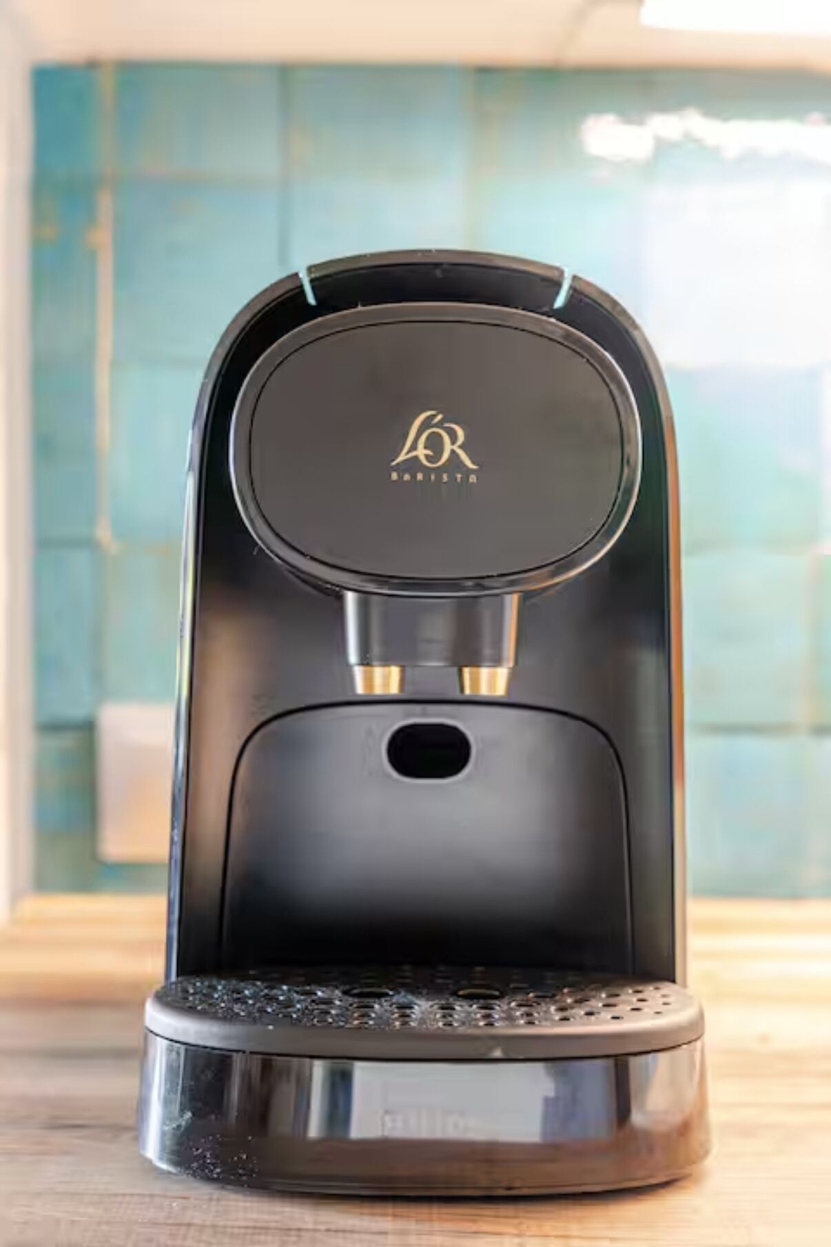 A coffee machine with a sleek black design and a logo on the top.