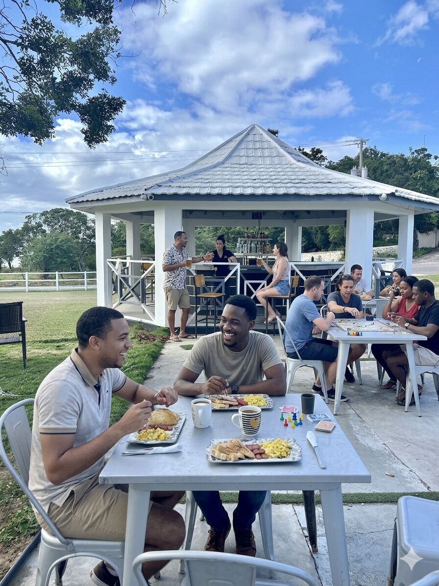 An outdoor dining area with tables and chairs, a gazebo in the background, and people engaged in conversation and dining.
