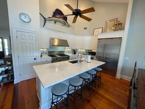 Een koelkast met diepvriezer, een microgolfoven, een oven, een kookplaat