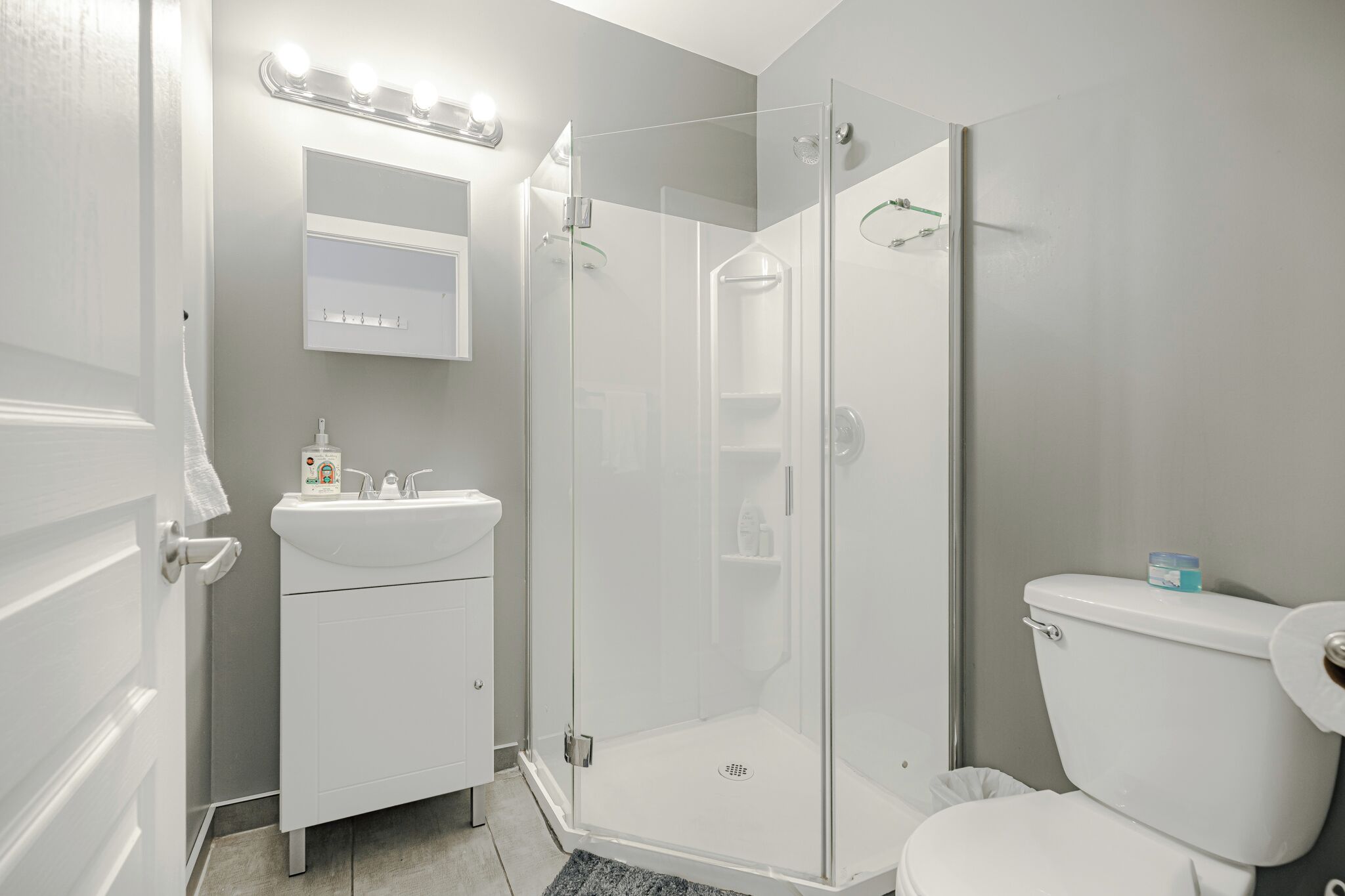 Une salle de bain moderne avec une douche à parois de verre, un lavabo blanc et des toilettes.