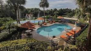 A pool area with lounge chairs, umbrellas, and a water feature. - *Fully Upgraded*GREAT 2BED SUITE RESORT ON INTERNATIONAL DRIVE NEAR SEA WORLD (Orlando)