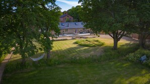 A house with a lawn, a hammock, and a patio area. - Stunning 19th century barn conversion in gorgeous Hampshire countryside (South Wonston)