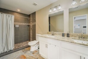 Bathtub, hair dryer, towels, shampoo