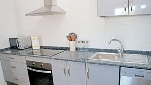 Eine moderne Küche mit Mikrowelle, Toaster, Spüle und Edelstahl-Schränken.