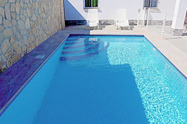 Relax by the pool surrounded by comfortable lounge chairs.