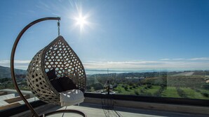 A hanging chair with a view of a landscape, a table with a glass, and a potted plant. - Villa Domenica with Heated Pool (Solin)