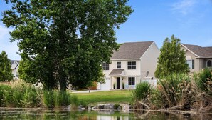 A residential house with a pond in front, surrounded by greenery and trees. - The Lake View: Family and business travel (Lehi)