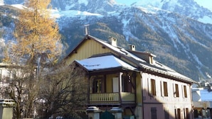 A traditional wooden building with a balcony, set against a backdrop of snow-capped mountains. - Le Chalet Suisse by Interhome (Chamonix)