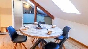 A round table with four black chairs, a skylight, and a kitchen in the background. - Le Chalet Suisse by Interhome (Chamonix)