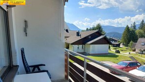 Un balcon avec vue sur une montagne et des maisons.