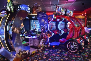 A gaming arcade with Halo-themed decorations, including a large display of a futuristic vehicle and multiple gaming stations.