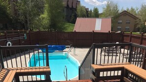 A hot tub and a rectangular pool on a wooden deck with railings. - Cozy, updated 2 Bedroom / 2 Bathroom condo (Steamboat Springs)