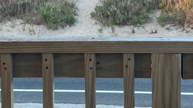 A sandy beach path leading to the ocean, viewed from a wooden railing. - Classic, semi ocean front OBX cottage steps away from the beach. (Kitty Hawk)