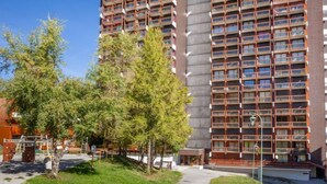 Ein mehrstöckiges Wohngebäude mit moderner Architektur, mit Balkonen und einem zentralen Innenhof.