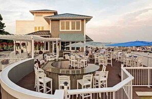 Un restaurant situé au bord de l’eau, avec une terrasse, un bar et une vue sur l’océan.