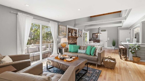 A spacious living area with a sofa set, a coffee table, and a view of the outdoors. - Shore House 003-DP Newly renovated in Dennis Port, 2 minute walk to the beach! (Dennis Port)